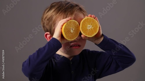 happy child looking through oranges for fresh vision or health