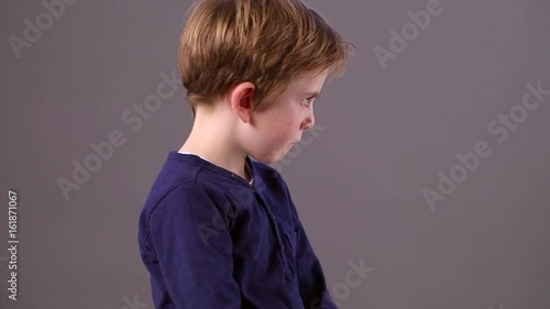 unhappy child shaking head and showing his profile for no