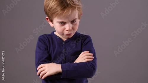 irritated child with arms folded showing his back for frustration