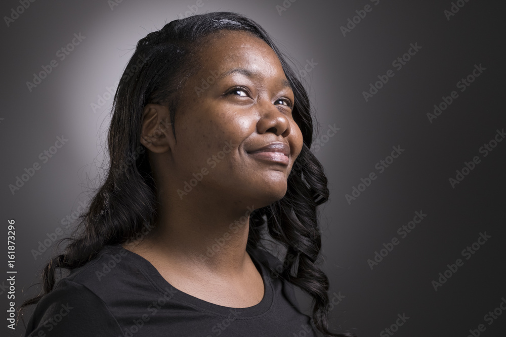 Portrait of a young black woman, eyes looking upward Portrait of a young black woman, eyes looking upward