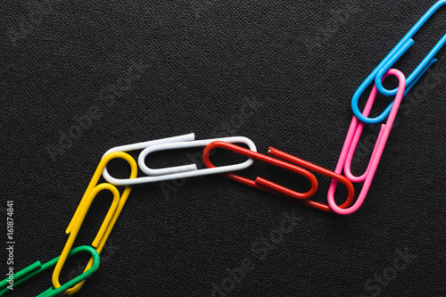 Chain made of paper clips on black background,teamwork and success concept.