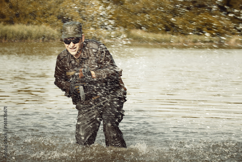 Naklejka premium Action soldier in uniform attacking with assault rifle