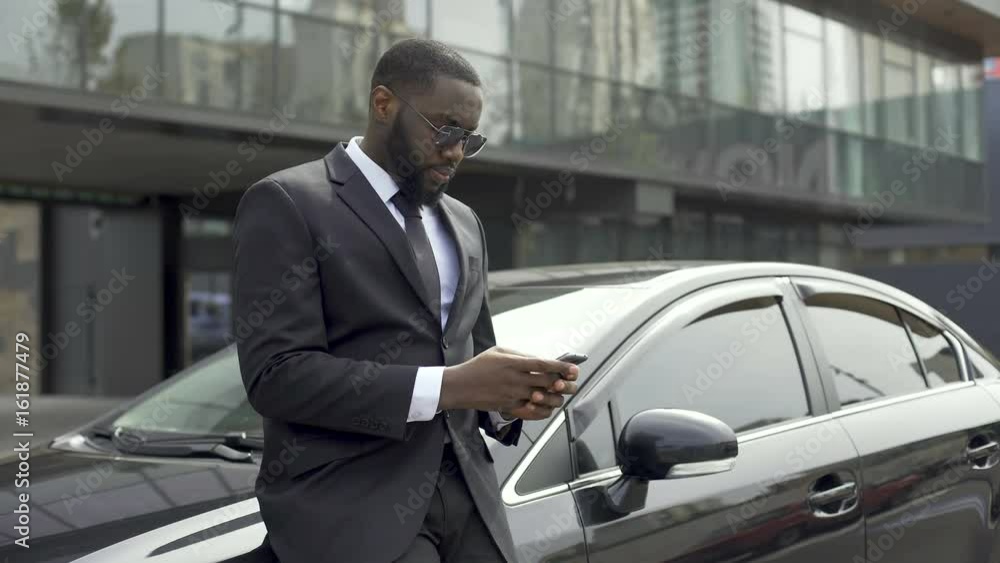 Rich Afro-American man waiting for partners near office building to do business Rich Afro-American man waiting for partners near office building to do business
