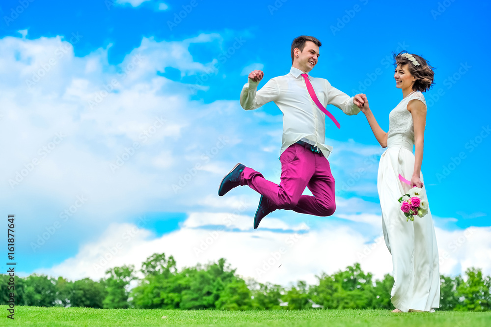 Happiness is in her hands: young and handsome bridegroom is fluttering in the air. Purpul pants