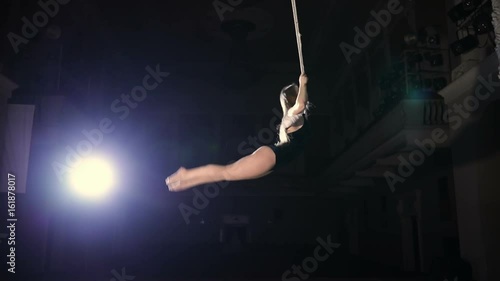 Slowmotion of female circus artist on a trapeze bar