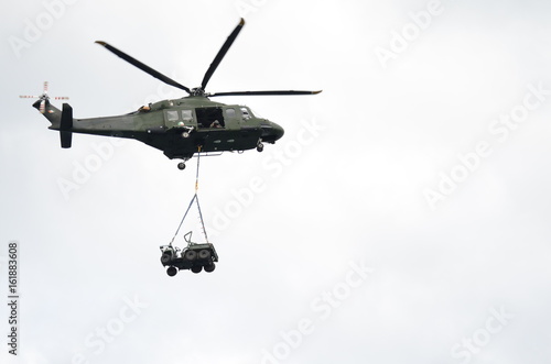 Green Military Helicopter Carrying a Jeep