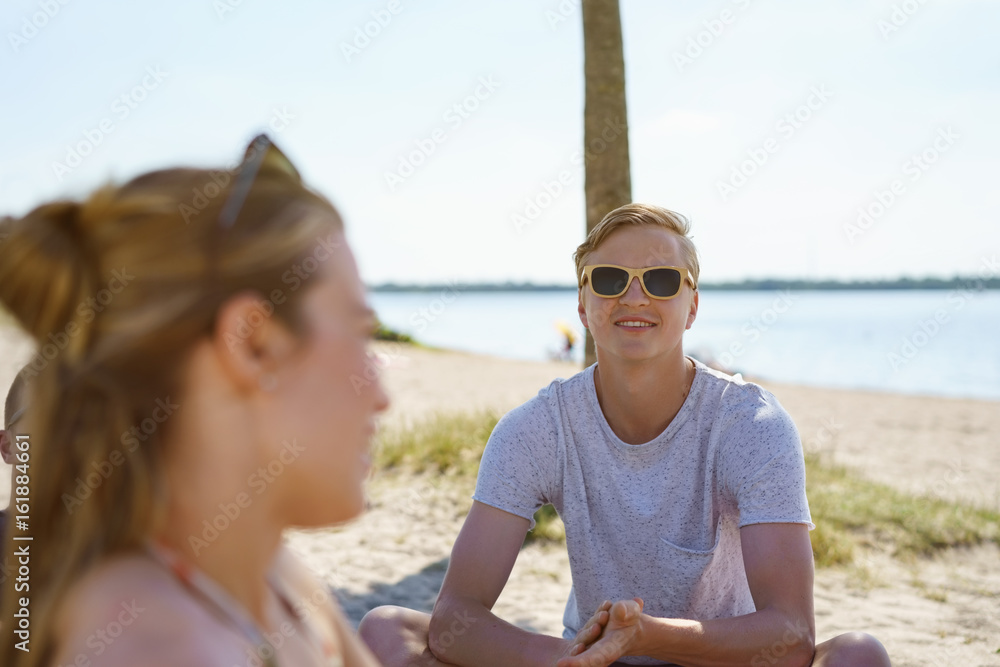 Young man in sunglasses on a sandy beach