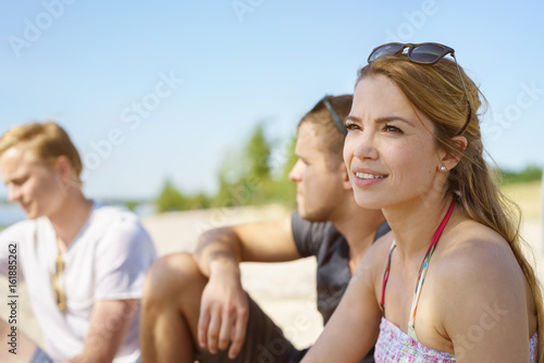 Thoughtful young woman sitting on a beach © contrastwerkstatt