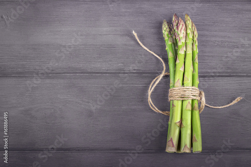 Bunch of fresh asparagus on wooden rustic background. Copy space