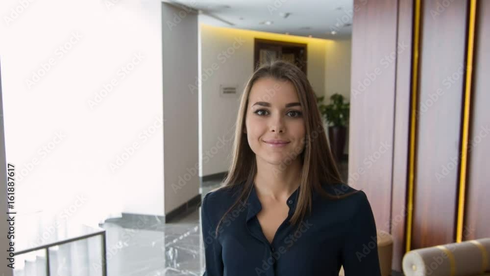 Pretty young office worker walking in corridor Pretty young office worker walking in corridor