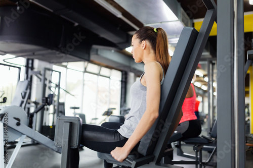 Young women exercising on machine in gym