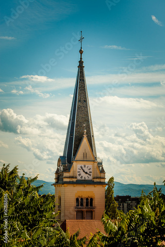 Photos Catholic church clock tower  among tree crowns