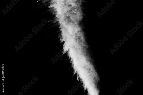 hrowing talcum powder out of hand. Stopping the movement of white powder on dark background.