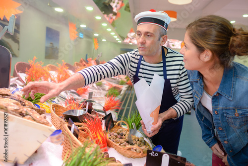 fishmonger assiting cutomer