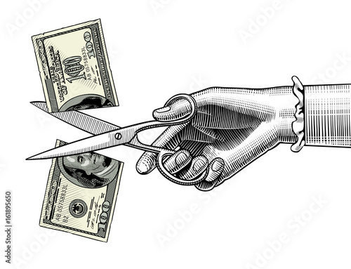 Woman's hand with scissors cutting a 100 dollar banknote