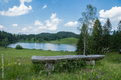 kleiner Bergsee mit Aussicht und Ruhebank