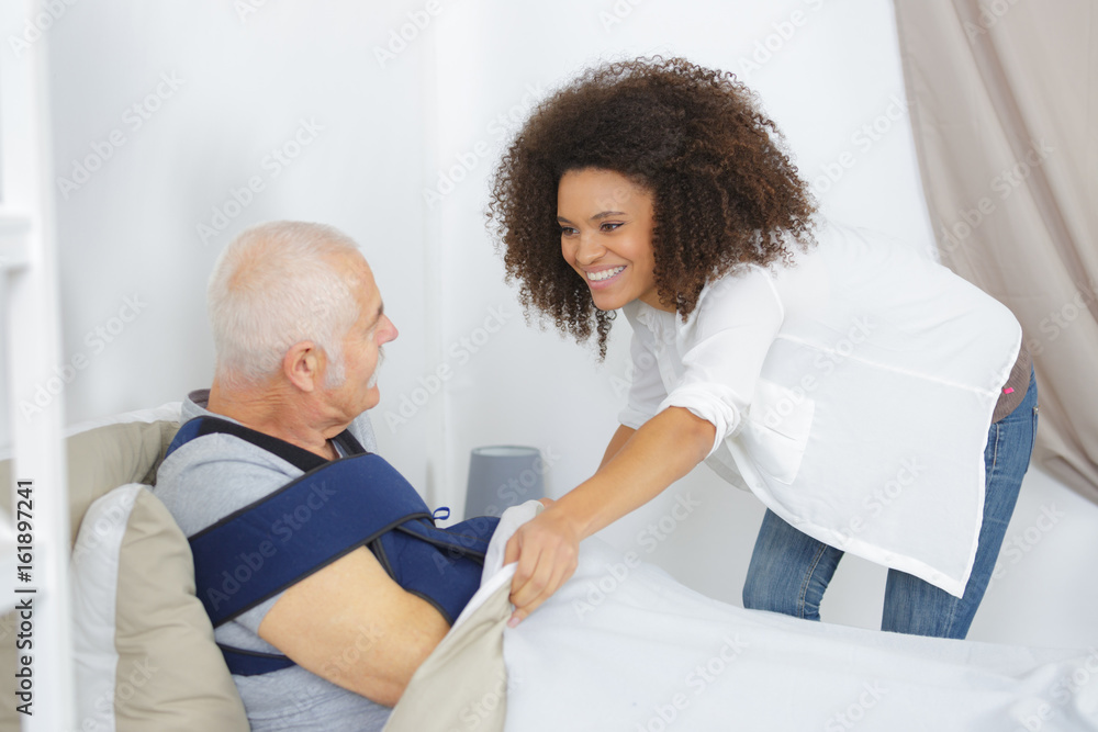 Fototapeta premium woman taking care of elderly man in nursing home