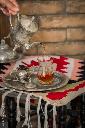 Fototapeta Naklejka Na Ścianę i Meble -  Tea set in oriental style in pear shaped glass with vintage kettle and dates fruit
