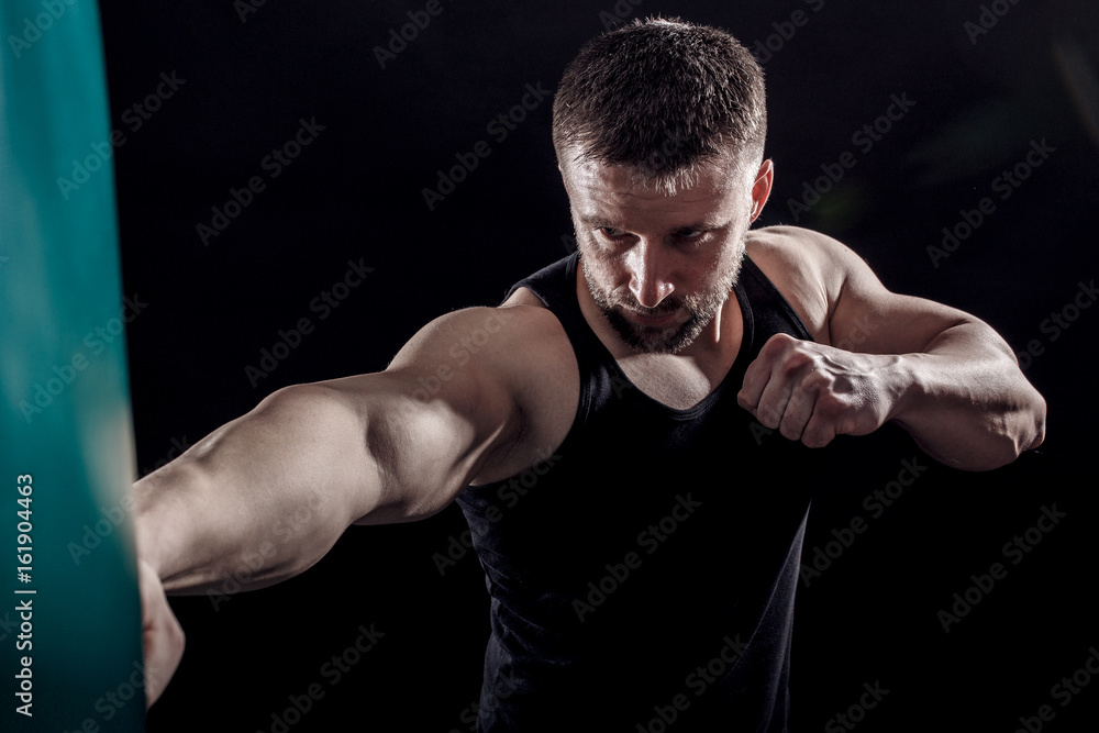Studio shot of male boxer punching a boxing bag. Studio shot of male boxer punching a boxing bag.