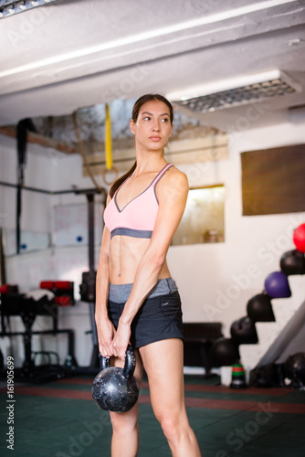 Young woman holding  kettle bells © Jovan