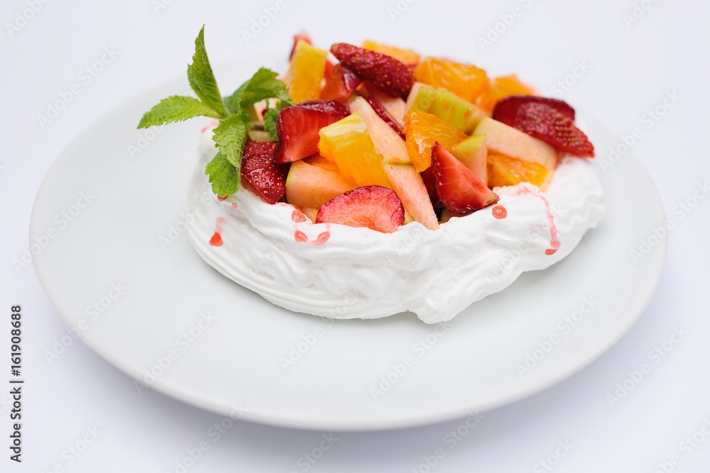 Dessert with cream, strawberries, oranges, apples and mint on white background Dessert with cream, strawberries, oranges, apples and mint on white background