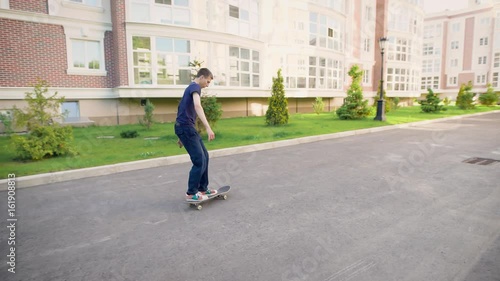 Wallpaper Mural An adult teenager performs a simple trick on a skateboard during a fast speed, the guy bounces and makes an ollie on his board Torontodigital.ca