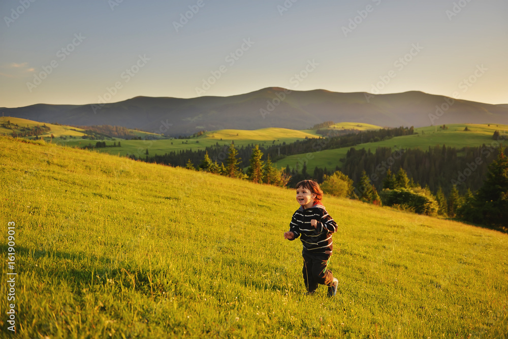 Kid running at sunset in the mountains