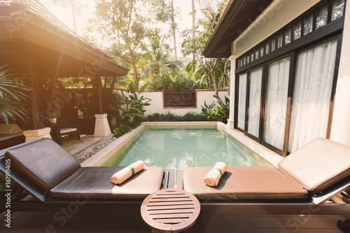 Sun beds and private swimming pool near luxury villa hotel. Sunny summer holiday © Annatamila