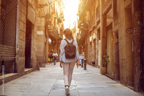 Traveling female walking on  European city street, tourism in Europe, travel background photo