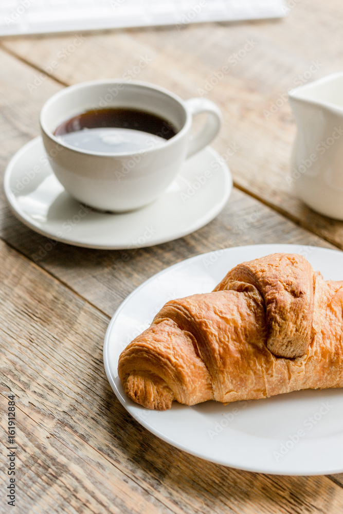 Office lunch with coffee, milk and croissant on wooden table background Office lunch with coffee, milk and croissant on wooden table background