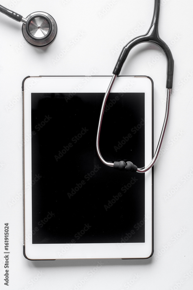 Medical equipment with stethoscope and tablet in doctor's office on white desk background top view mock-up Medical equipment with stethoscope and tablet in doctor's office on white desk background top view mock-up