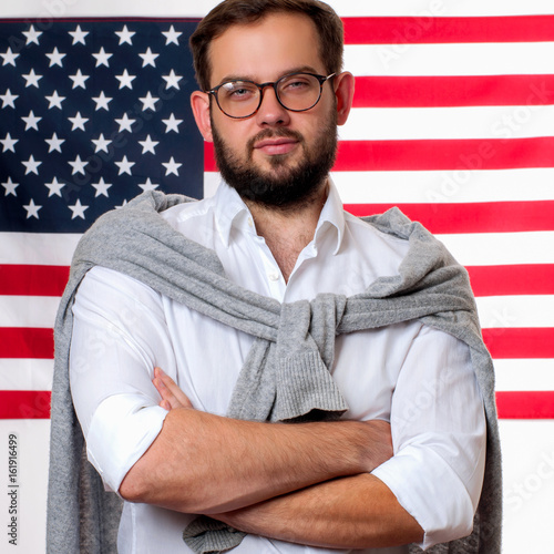 4th of July. Smiling young man on United States flag background. photo