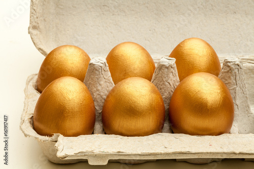 hand painted gold eggs in an egg carton