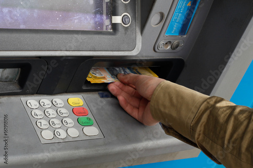 Male hand taking Australian money from an ATM