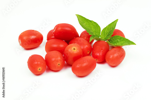 Cherry tomatoes with basil leaf on a white background