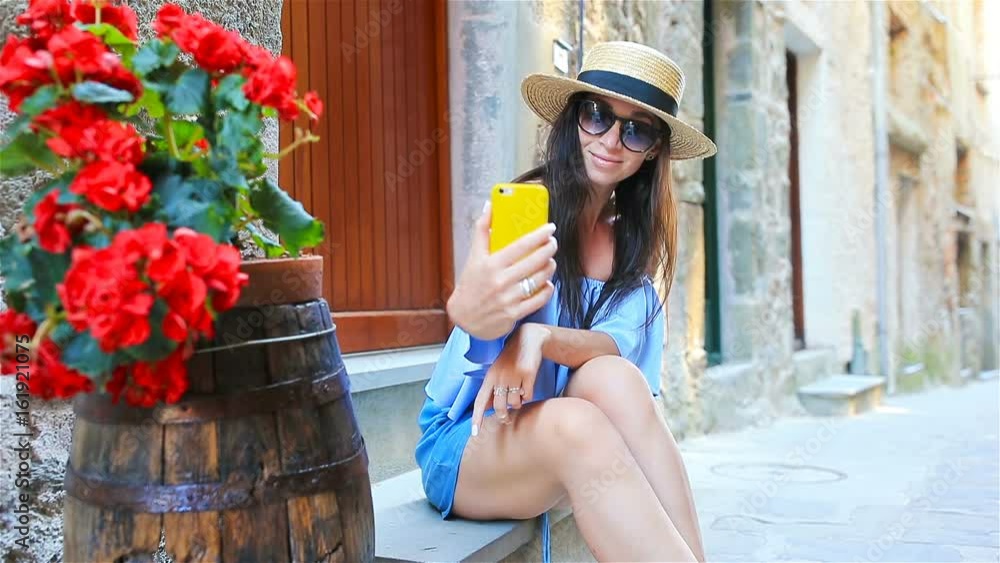 Beautiful happy woman taking selfie on european vacation in Cinque Terre. Young caucasian tourist taking selfie at the old street Beautiful happy woman taking selfie on european vacation in Cinque Terre. Young caucasian tourist taking selfie at the old street