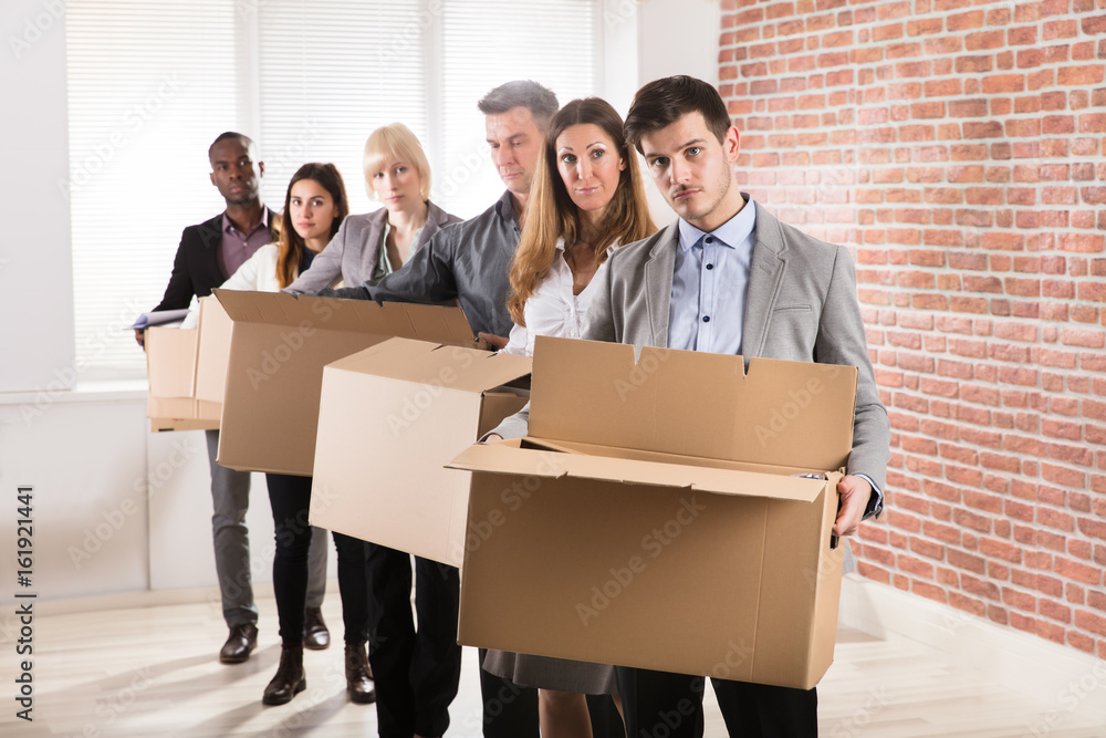 Row Of Businesspeople Standing With Cardboard Boxes Row Of Businesspeople Standing With Cardboard Boxes