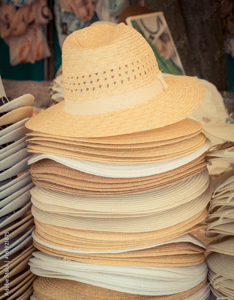 Collection of handmade straw hats on stall at bazaar