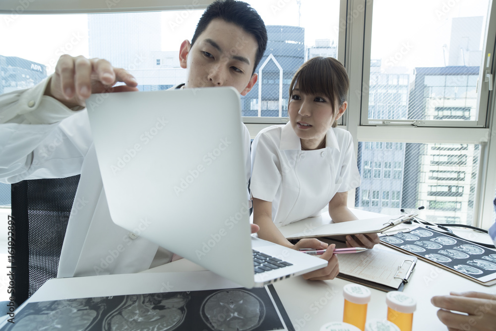 Doctors and nurses are meeting while watching laptops Doctors and nurses are meeting while watching laptops