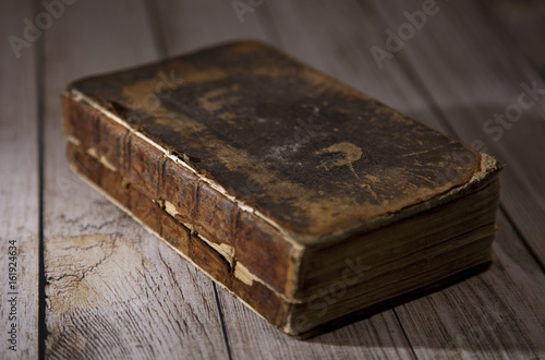 White Canvas New Testament Closed on a Wooden Table