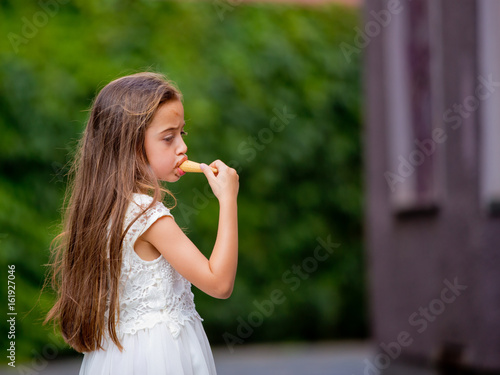 Wallpaper Mural A little girl in a white dress is eating ice cream. Torontodigital.ca