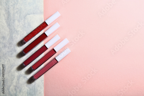 Set of decorative cosmetics lip gloss on light colorful background.