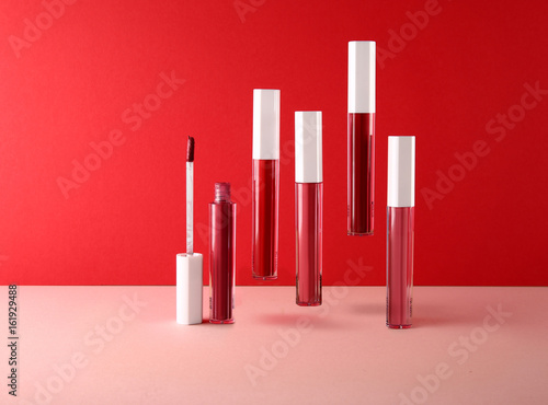 Set of decorative cosmetics lip gloss on light colorful background.