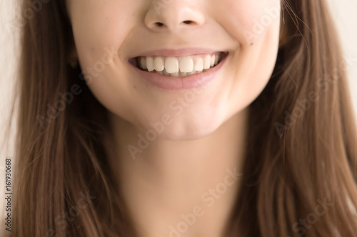 Close up image of beautiful female wide smile. Young woman toothy smiling face front view. Teenager girl with perfect healthy white teeth. Dental care concept