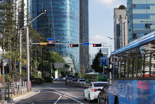 View of modern urban road with many tries, blue blured bus and white car. Public transport in city concept photo
