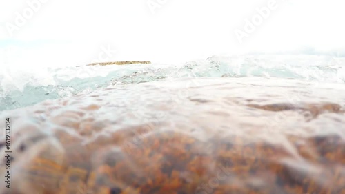 Turquoise Waves Cover Camera Red Seaweeds Underwater Cloudy Sky Rocks in Sea photo