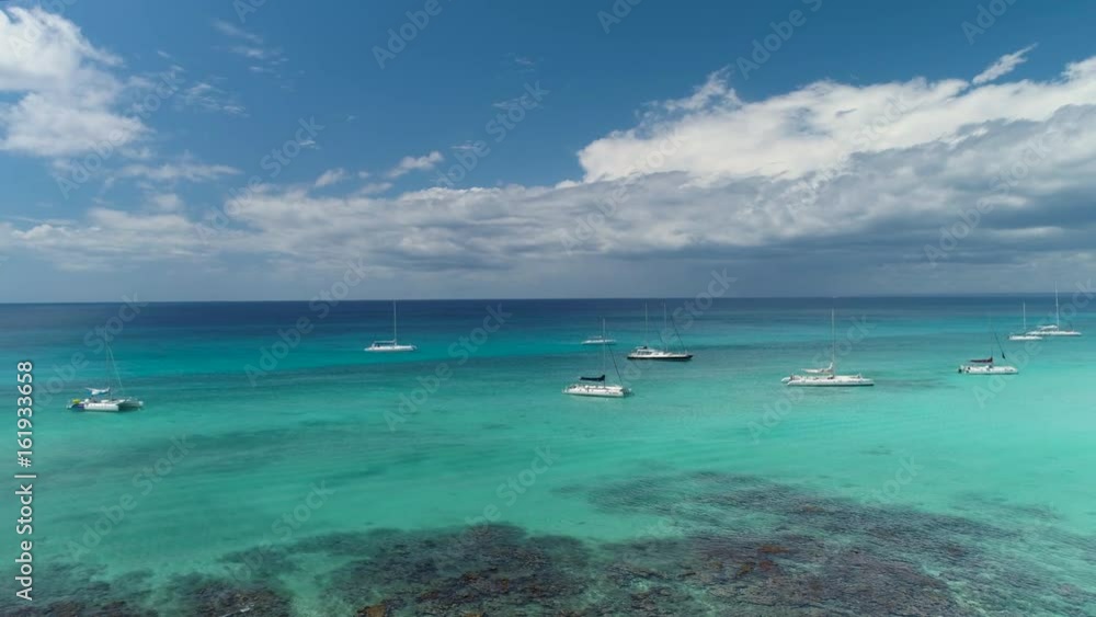 Catamarans, speed boats and yachts in Caribbean sea near tropical island Catamarans, speed boats and yachts in Caribbean sea near tropical island