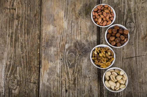 Fototapeta Naklejka Na Ścianę i Meble -  Four bowls with nuts on a  wooden table