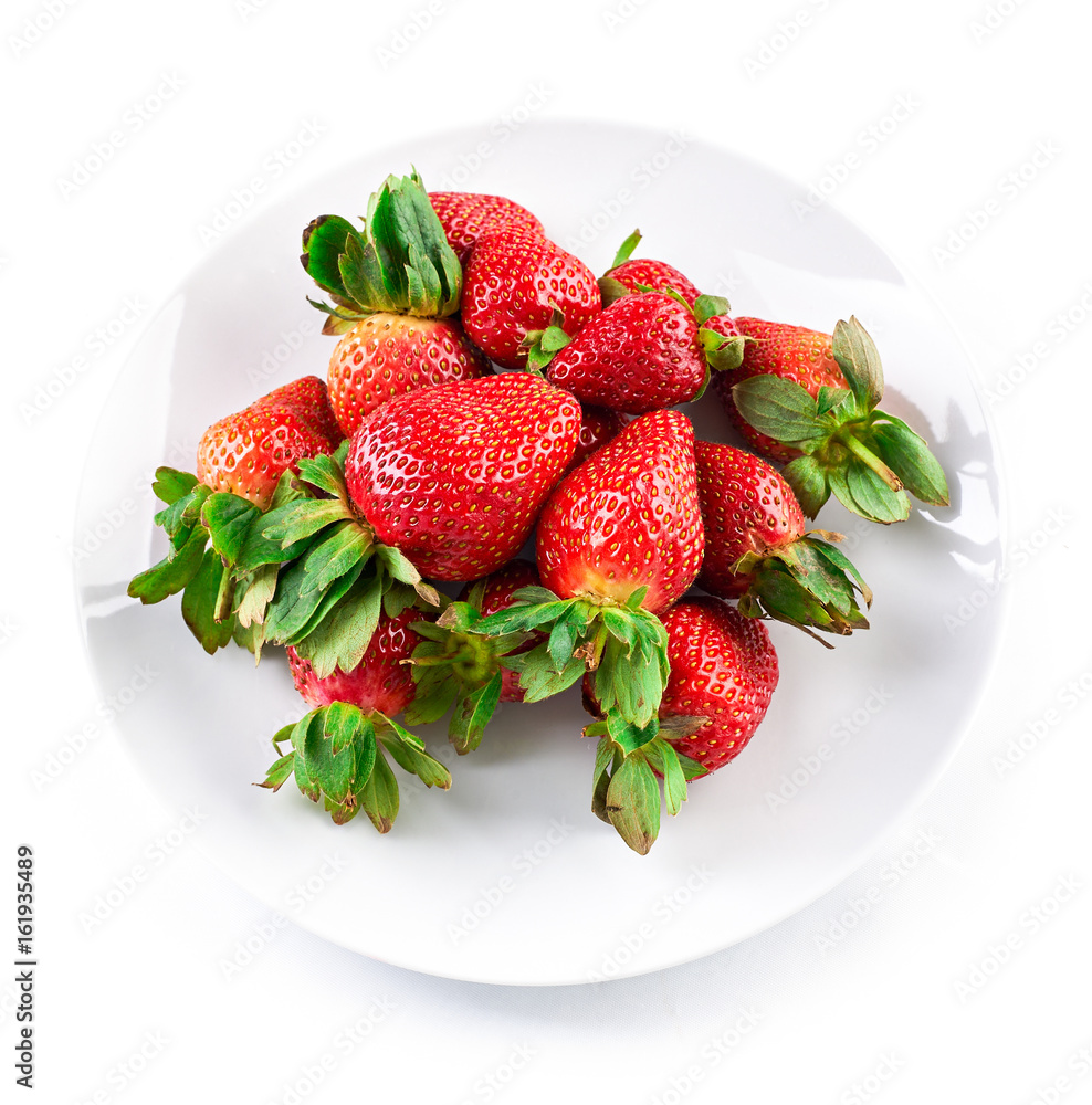 Ripe red strawberry on white plate isolated on white background. Top view. Flat lay. Ripe red strawberry on white plate isolated on white background. Top view. Flat lay.