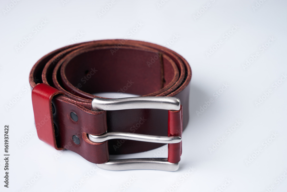 Stylish brown leather belt with a buckle isolated on white background. Stylish brown leather belt with a buckle isolated on white background.